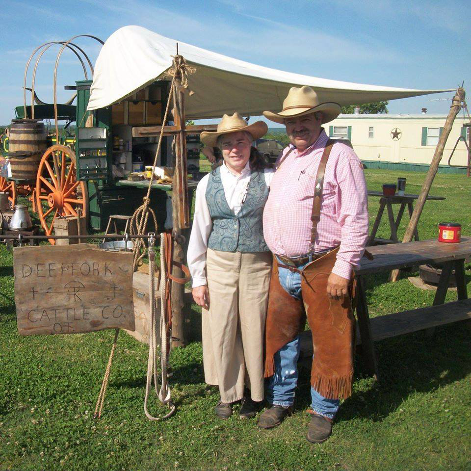 Sheryl and David Roberts in front of the Deepfork Cattle Company Chuckwagon